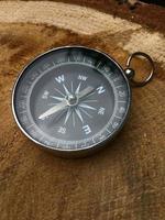 Compass in a metal case on the stump of the tree photo