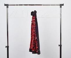 black women's blouse with red sequins hanging on a white iron hanger photo