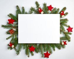 congratulatory Christmas background with an empty white sheet and green branches of spruce photo