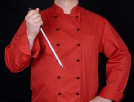 chef in red uniform holds knife sharpening tool photo