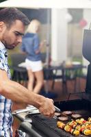 Young man grilling food photo