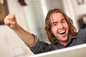 joven feliz usando computadora portátil foto