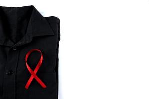 Red ribbon on a black shirt on a white background. Modern treatment and healthcare. AIDS awareness concept. photo