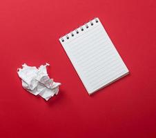 notebook with white sheets and a crumpled ripped out sheet of paper photo