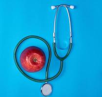 estetoscopio médico verde y manzana roja madura foto