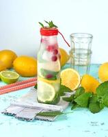 summer refreshing drink lemonade with lemons, cranberry, mint leaves photo