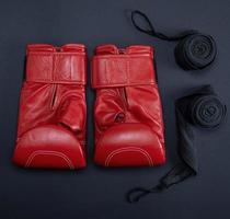 red leather boxing gloves and a black textile bandage photo