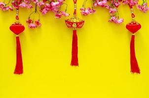 colgantes colgantes para el ornamento del año nuevo chino, el significado de la palabra es riqueza con flores chinas sobre fondo amarillo. foto