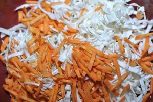 Shredded white cabbage with grated carrots in a basin photo