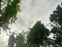 beautiful natural scenery in the blue sky, white clouds and many green trees around it photo