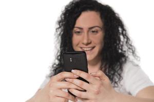 Portrait of a happy woman using mobile phone isolated over white background photo