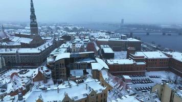 hermoso país de las maravillas de invierno sobre el casco antiguo de riga. mercado navideño con árbol de navidad en el centro de la ciudad. espíritu mágico de vacaciones en europa. vista aérea. video