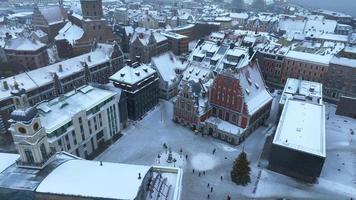 Beautiful winter wonderland over Riga old town. Christmas market with Christmas tree in the center of the city. Magical holiday spirit in Europe. Aerial view.