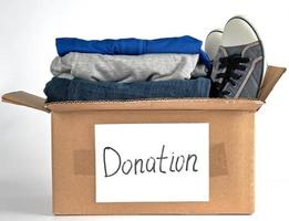 folded clothes in a brown paper box with the inscription donation photo