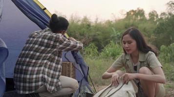 una pareja va a acampar al bosque con su esposa ayudándoles a entregar sus pertenencias y bolsas de campamento. pareja haciendo turismo de naturaleza en vacaciones. concepto de turismo. video