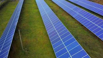 planta de energía solar en verano. baterías solares innovadoras en el campo. producción de energía limpia. vista aérea video