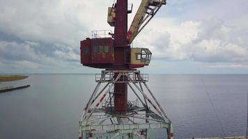 een oud verlaten roestig kraan in de zeehaven. video