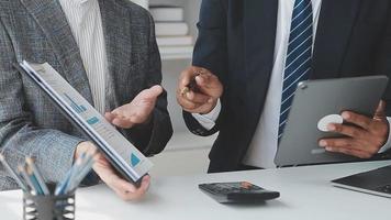 Financial analysts analyze business financial reports on a digital tablet planning investment project during a discussion at a meeting of corporate showing the results of their successful teamwork. video