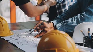 costruzione e struttura concetto di ingegnere o architetto incontro per progetto Lavorando con compagno e ingegneria utensili su modello edificio e planimetria nel Lavorando luogo, contrarre per tutti e due aziende. video