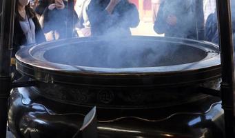 enorme quemador de incienso de bronce en el templo sensoji en asakusa, donde la gente se baña las manos y la cara en el humo para protegerse de las enfermedades foto