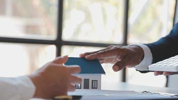 l'agent de courtage immobilier livre un échantillon d'une maison modèle au client, un contrat de prêt hypothécaire fait un bail et achète une maison et un concept d'assurance habitation video