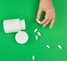 white plastic can and scattered oval pill photo