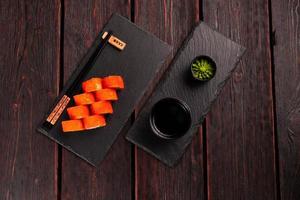 Roll with fish sushi with chopsticks - asian food concept photo