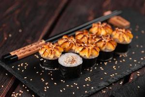 Rollo de sushi maki japonés caliente con primer plano de anguila - concepto de comida asiática foto