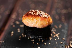 gunkan de camarones al horno sobre fondo de madera. simple sushi gunkan con tartar de gambas con mayonesa en un estilo minimalista. comida japonesa - nigiri sushi en nori. nigiri sushi con pescado foto