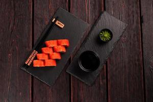 Roll with fish sushi with chopsticks - asian food concept photo