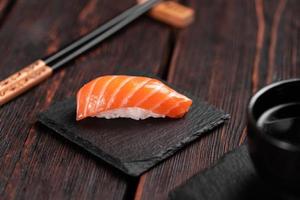 comida japonesa de sushi. sushi nigiri con primer plano de salmón sobre fondo natural de piedra con mesa de madera foto