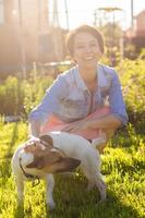 Young woman plays with her dog on the grass on backyard. The concept of animals and friendship or pet owner and love photo