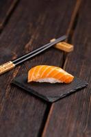 comida japonesa de sushi. sushi nigiri con salmón sobre fondo natural de piedra con mesa de madera foto