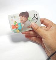 West Java, Indonesia on July 2022. Isolated photo of a hand holding a loyalty card, Mothercare ID Priviledge Card.