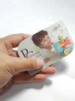 West Java, Indonesia on July 2022. Isolated photo of a hand holding a loyalty card, Mothercare ID Priviledge Card.