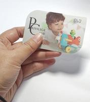 West Java, Indonesia on July 2022. Isolated photo of a hand holding a loyalty card, Mothercare ID Priviledge Card.