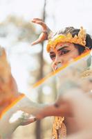 An Asian man faces in makeup with a golden crown on her head looks angry while posing photo