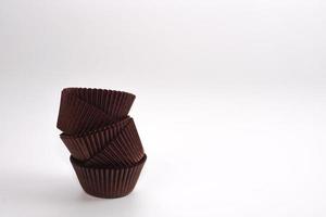 Brown cupcake cases on white background. Material for baking. photo