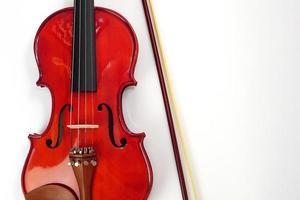 violín apoyado contra un fondo blanco de pared en blanco con espacio de copia. instrumento y concepto musical. foto