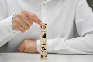 Hand holding a wooden block cube the top one with target icon symbol. Business strategy and target of business. photo