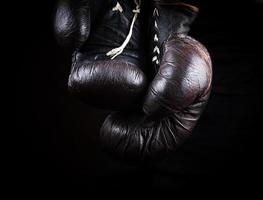 pair of very old brown boxing gloves hanging photo