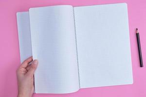 empty open notebook in a cell and a female hand photo