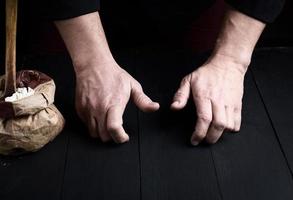 dos manos masculinas sobre una mesa de madera negra foto
