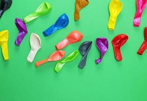 colorful deflated balloons on a green background photo