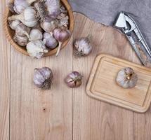 unpeeled fresh garlic fruits in wooden bowl photo