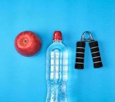 plastic water bottle, red ripe apple and sports expander photo