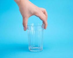 woman's hand holding an empty transparent glass photo