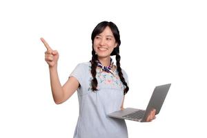 retrato de una hermosa y feliz joven mujer asiática independiente vestida de mezclilla usando un trabajo portátil con éxito en el fondo blanco foto