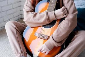 Young woman playing guitar at home photo