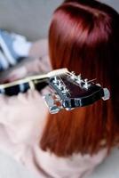 mujer joven, tocar la guitarra, en casa foto